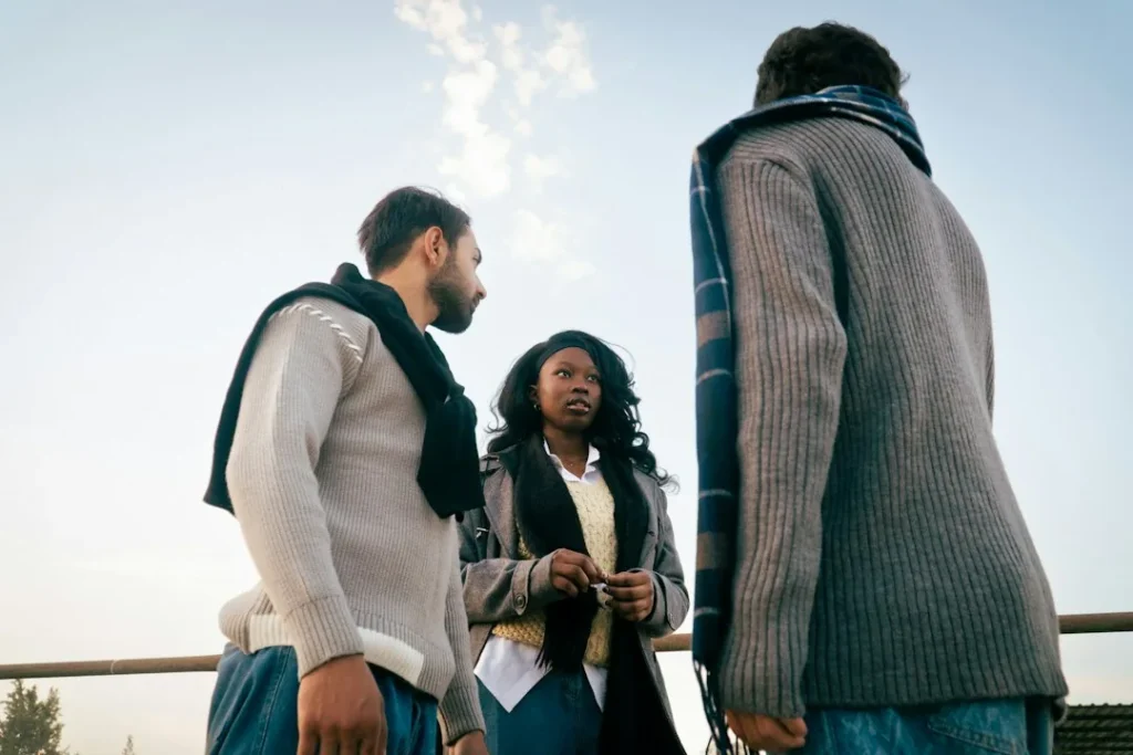 Trois personnes échangent à l'extérieur